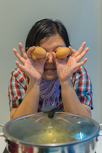 亚洲女人把肉蛋放进火锅里做饭