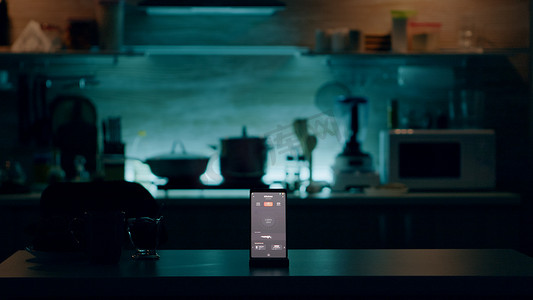 带有智能软件的手机放置在厨房的桌子上，无人在场