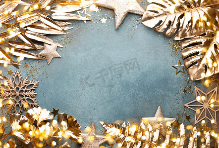 新年庆祝活动和圣诞节背景，有金色的花朵、雪、星星和圣诞装饰的顶视图。