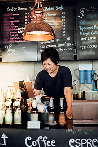 亚洲女性在咖啡店担任收银员
