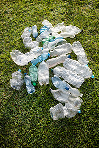 可生物降解的摄影照片_废弃在草地上的用过的塑料瓶