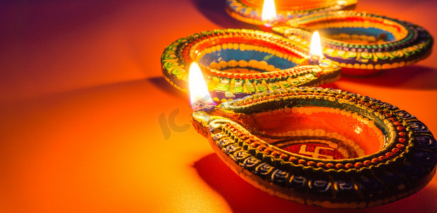 印度文化摄影照片_印度节日排灯节，Diya 油灯在五颜六色的 rangoli 上点亮。