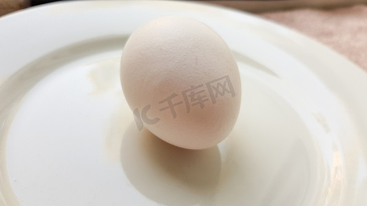 白盘上一整个生鸡蛋