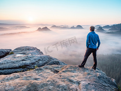 背手人物摄影照片_孤独的徒步旅行者在山上放松并观看日落