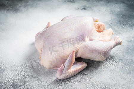 厨房的桌子上放着生的散养整只鸡。