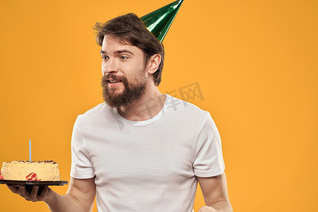 留着胡子、戴着帽子庆祝生日聚会黄色背景的帅哥