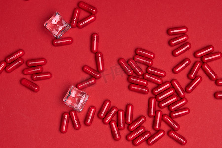 药片图案摄影照片_许多红色胶囊药片维生素 B3 在彩色背景上。