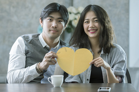 成婚摄影照片_亚洲男女情侣手握心形剪纸机智