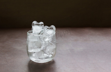桌子上玻璃杯中的心形纯冰水，有复制空间