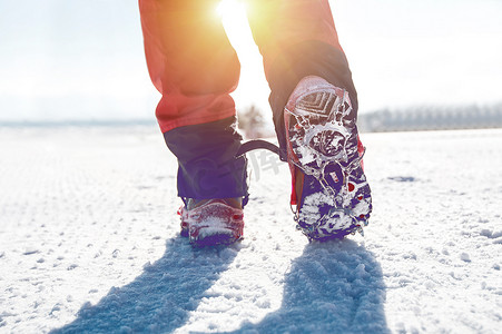 冬天穿着雪鞋和鞋钉在雪地上行走的视图。