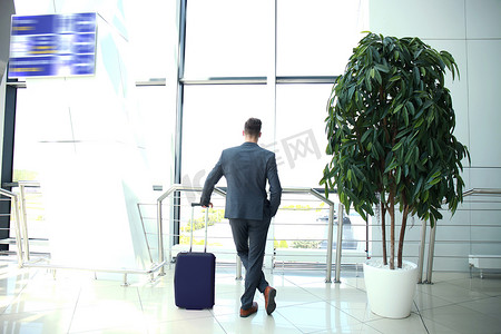 带着手提箱的商人在机场大厅。