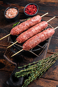 塔科夫摄影照片_生的科夫塔或卢拉烤肉串放在烤架上，配上香草。