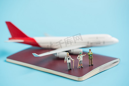 护照簿上的微型旅行者和飞机模型