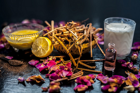 粉利摄影照片_黑色木质表面上的 manjistha 或印度茜草根面罩，由 manjistha 根粉、柠檬、牛奶和一些必需的玫瑰油组成。