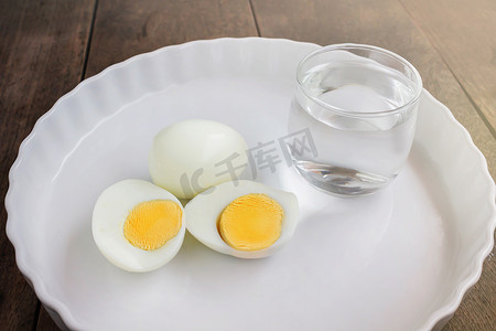 水煮汉虾摄影照片_早餐费中用一杯水在白盘上煮鸡蛋
