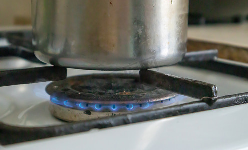油污的厨房摄影照片_厨房里的脏煤气灶，用于烹饪，表面有植物油污和烧焦的食物残渣，特写。