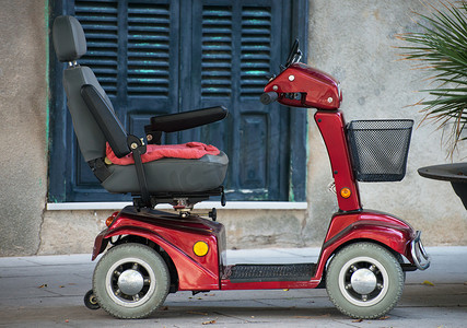 便携手推车摄影照片_供残疾人使用的机动轮椅车。