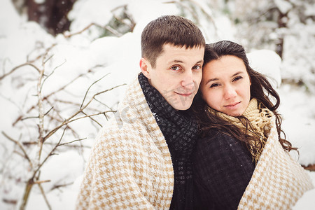一个男孩和一个女孩穿着温暖的衣服和围巾在雪天散步