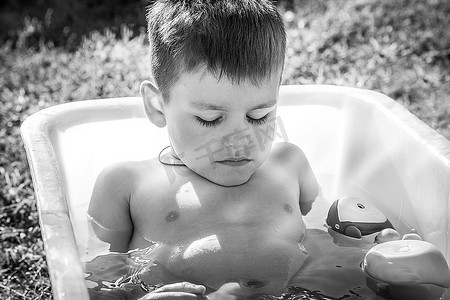 农舍图片摄影照片_黑白图片悲伤的小男孩坐在浴缸里