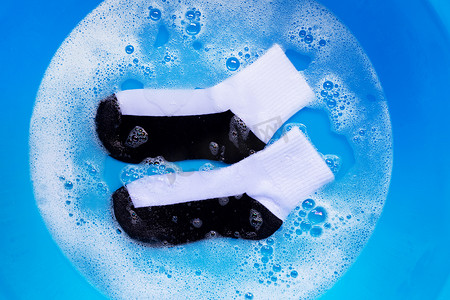 脏袜子浸泡在粉状洗涤剂水中溶解。