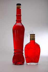 玻璃瓶背光摄影照片_红色伏特加瓶