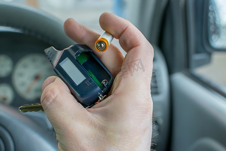 男人更换汽车防盗器钥匙扣中的电池