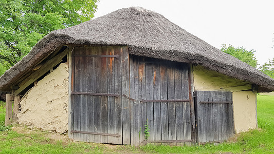 乌克兰，基辅 — 2020年6月11日。夏天，村里有茅草屋顶的乌克兰老农民房屋或谷仓。