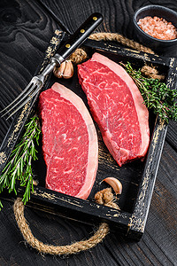 木托板摄影照片_生巴西皮卡尼亚牛排或顶级沙朗牛肉牛排放在木托盘中。