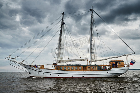俄罗斯，圣彼得堡，2020年8月31日：白色古董护卫舰出海，暴风雨天空降低，帆降下，桅杆和绳索