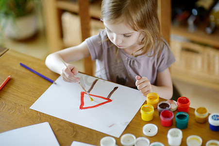 可爱的女孩在幼儿园用颜料画画