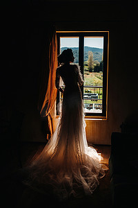 一位身着婚纱、五官端庄的美丽新娘在房间内部摆出姿势。