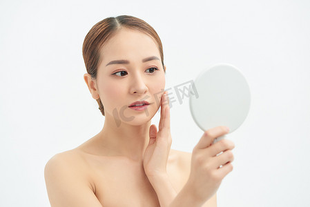 美丽的亚洲女人检查她的皮肤、皮肤护理、痤疮治疗。