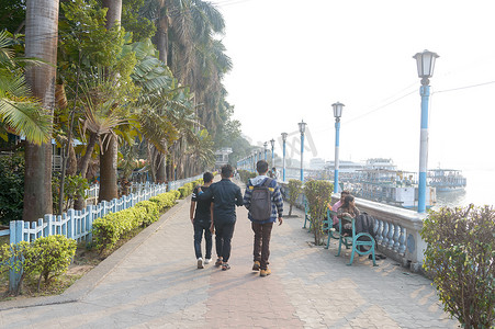 朋友们在千禧生态旅游公园和休闲河滨美化区安静轻松的夜晚沿着街道人行道散步。