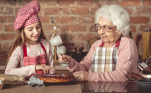 奶奶和她的孙女一起煮馅饼
