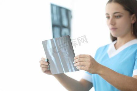 手部x光片摄影照片_创伤科医生在诊所特写中观察手部 X 光片