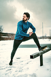 冬天，男子在公共场所做伸展运动。
