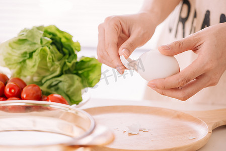 女性的手正在剥鸡蛋。