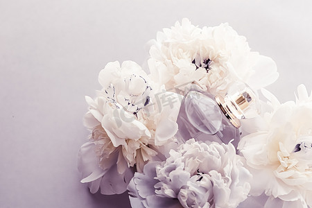 紫罗兰香水瓶作为牡丹花背景下的奢侈香水产品、香水广告和美容品牌