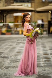 意大利佛罗伦萨老城中心，身穿粉色连衣裙、捧花的新娘站立