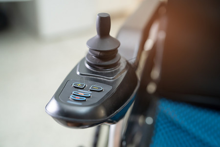便携手推车摄影照片_老年患者电动轮椅不能行走或残疾人在家庭或医院使用，健康强大的医疗理念。