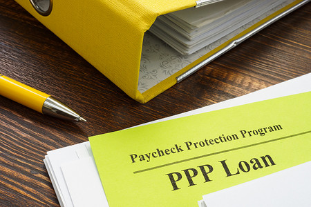 带薪资的聘请书摄影照片_薪资保护计划或 PPP 贷款文件和黄色文件夹。