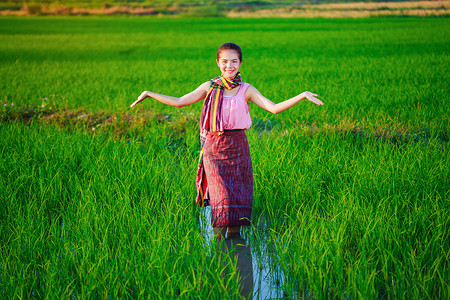绿色稻田里美丽的农妇