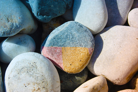 许多圆形的彩色石头彼此都相等，中间有一块奇怪的彩色石头，碎片不同