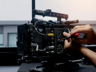 技术人员使用螺丝刀更换电影摄影机的冷却风扇。