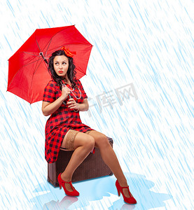 海报背景下雨摄影照片_坐在手提箱里的带伞海报风格的年轻女子
