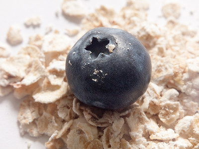 蓝莓燕麦摄影照片_一堆燕麦上的蓝莓特写