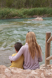 母亲和儿子看着浩瀚的河流