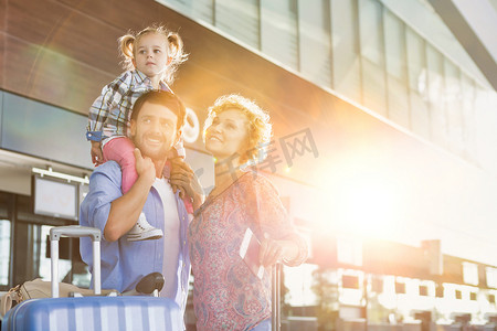 一个带着镜头光晕抵达机场的幸福家庭的肖像