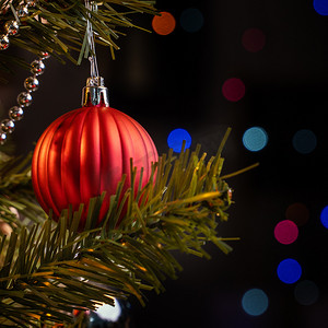 火星光点摄影照片_美丽的圣诞装饰概念，挂在圣诞树上的小玩意，上面有闪闪发光的光点，模糊的深黑色背景，宏观细节，特写。