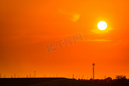 美丽的橙色夕阳天空，工厂屋顶和飞鸟